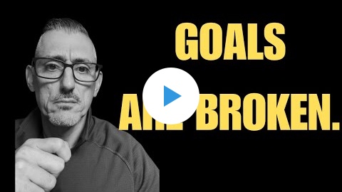 Play button over a man pointing beside the words Goals Are Broken