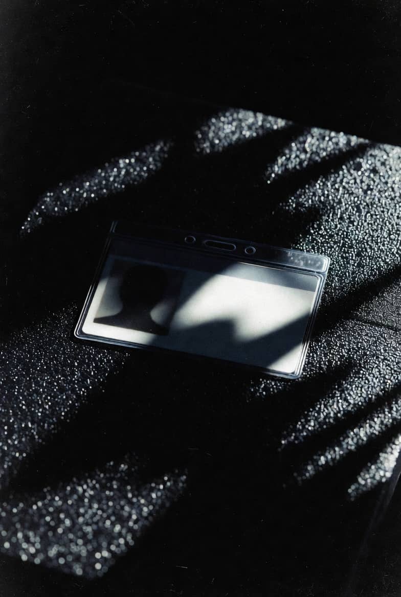Blank ID badge with a silhouette photo, crossed by hard light